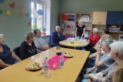 na zdjęciu - suczestnicy spotkania - Seniorzy, Dyrektor OPS Mieroszów oraz Burmistrz Mieroszowa wręczający opaski