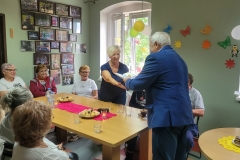 na zdjęciu - suczestnicy spotkania - Seniorzy, Dyrektor OPS Mieroszów oraz Burmistrz Mieroszowa wręczający opaski