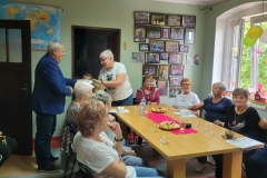 na zdjęciu - suczestnicy spotkania - Seniorzy, Dyrektor OPS Mieroszów oraz Burmistrz Mieroszowa wręczający opaski