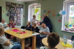na zdjęciu - suczestnicy spotkania - Seniorzy, Dyrektor OPS Mieroszów oraz Burmistrz Mieroszowa wręczający opaski