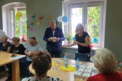 na zdjęciu - suczestnicy spotkania - Seniorzy, Dyrektor OPS Mieroszów oraz Burmistrz Mieroszowa wręczający opaski
