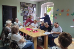 na zdjęciu - suczestnicy spotkania - Seniorzy, Dyrektor OPS Mieroszów oraz Burmistrz Mieroszowa wręczający opaski