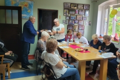 na zdjęciu - suczestnicy spotkania - Seniorzy, Dyrektor OPS Mieroszów oraz Burmistrz Mieroszowa wręczający opaski