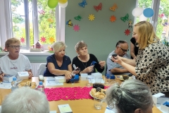 na zdjęciu - suczestnicy spotkania - Seniorzy, Dyrektor OPS Mieroszów oraz Burmistrz Mieroszowa wręczający opaski