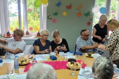 na zdjęciu - suczestnicy spotkania - Seniorzy, Dyrektor OPS Mieroszów oraz Burmistrz Mieroszowa wręczający opaski