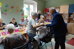 na zdjęciu - suczestnicy spotkania - Seniorzy, Dyrektor OPS Mieroszów oraz Burmistrz Mieroszowa wręczający opaski