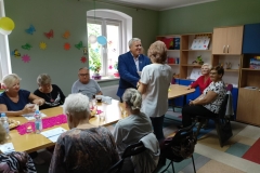 na zdjęciu - suczestnicy spotkania - Seniorzy, Dyrektor OPS Mieroszów oraz Burmistrz Mieroszowa wręczający opaski