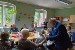 na zdjęciu - suczestnicy spotkania - Seniorzy, Dyrektor OPS Mieroszów oraz Burmistrz Mieroszowa wręczający opaski
