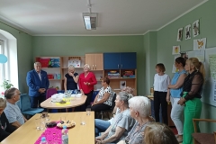 na zdjęciu - suczestnicy spotkania - Seniorzy, Dyrektor OPS Mieroszów oraz Burmistrz Mieroszowa wręczający opaski