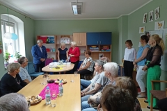 na zdjęciu - suczestnicy spotkania - Seniorzy, Dyrektor OPS Mieroszów oraz Burmistrz Mieroszowa wręczający opaski